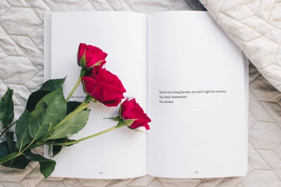 Roses on top of an open book beside a page that reads "You're not wrong because you aren't right for someone You were mismatched Not broken"