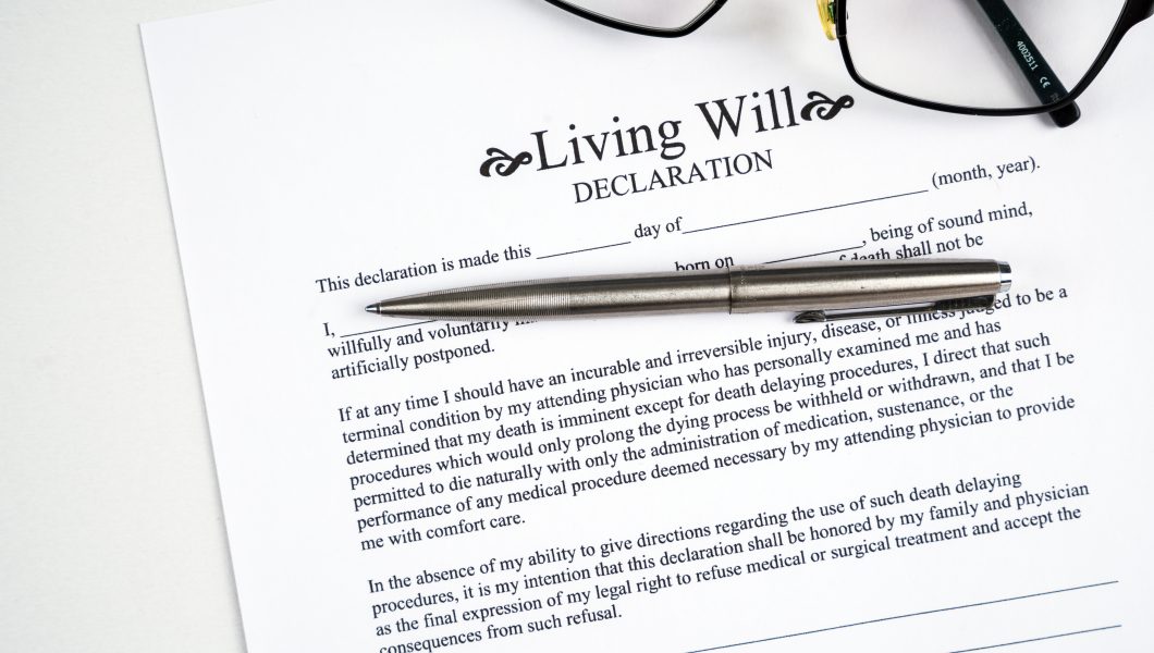 Living will declaration form with glasses and silver pen.