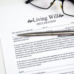 Living will declaration form with glasses and silver pen.